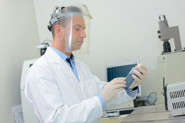 Laboratory technician working behind visor