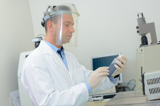 Laboratory technician working behind visor