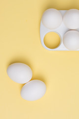 Happy Easter concept. White eggs on yellow background close up. Flat lay. Minimal concept. Top view. Design, visual art.