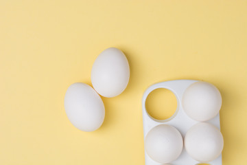 Happy Easter concept. White eggs on yellow background close up. Flat lay. Minimal concept. Top view. Design, visual art.