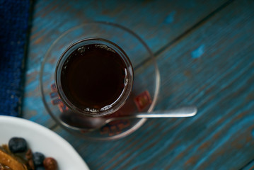 Pakhlava or baklava with nuts and honey. Novruz tray with Azerbaijan national pastry and drinking glass of black tea on blue rustic wooden table background, top view. Delicious dessert holiday food