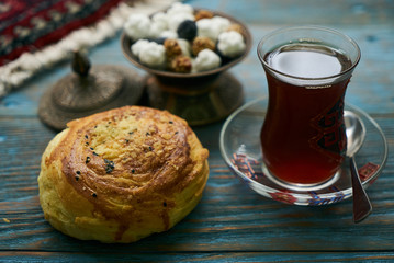 Novruz holiday with Azerbaijan national pastry Gogal and glass of black tea on rustic wooden table background, Delicious dessert holiday food