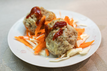 Meatballs with sauce on plate with salad.