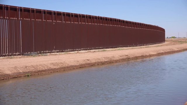 A tributary of the Colorado River flows along the border wall between the US and Mexico.