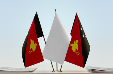 Two flags of Papua New Guinea with a white flag in the middle