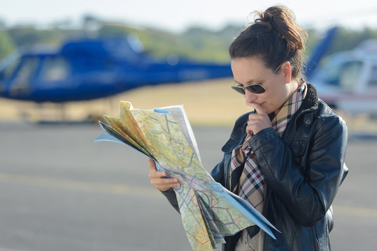 woman helicopter in background pilot reading map