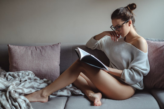 Sexy girl reading book on the sofa