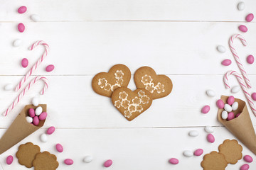 Frame Candies and cookies in the form of heart Top view White wooden Background