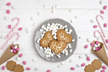 .Frame Candies and cookies in the form of heart Top view White wooden Background