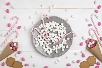 .Frame Candies and cookies in the form of heart Top view White wooden Background