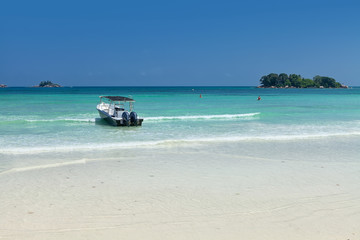 Fototapeta na wymiar White coral sand on а tropical beach. Praslin island, Seychelles