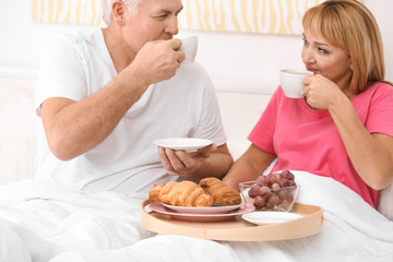Obraz na płótnie Canvas Mature couple having breakfast in bed. Romantic morning