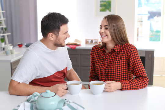 Cute young lovely couple drinking tea in kitchen
