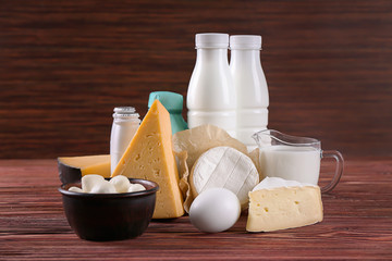 Different dairy products and egg on wooden table