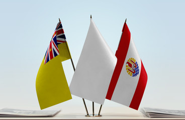 Flags of Niue and French Polynesia with a white flag in the middle