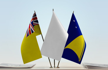 Flags of Niue and Tokelau with a white flag in the middle