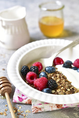 Healthy breakfast : granola, yogurt and fresh berries with honey.