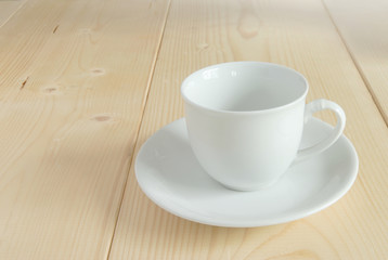 Fototapeta na wymiar Blank white cup on wooden floor.