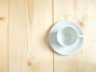 Blank white cup on wooden floor.