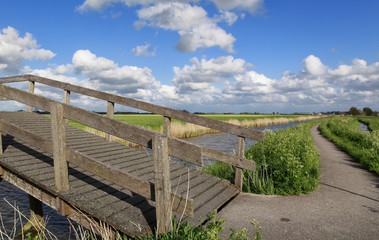 Fototapeta na wymiar bike path and bridge via canal and blue sky
