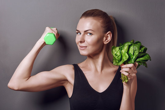 girl in sports top holds gattelu and bunches of spinach