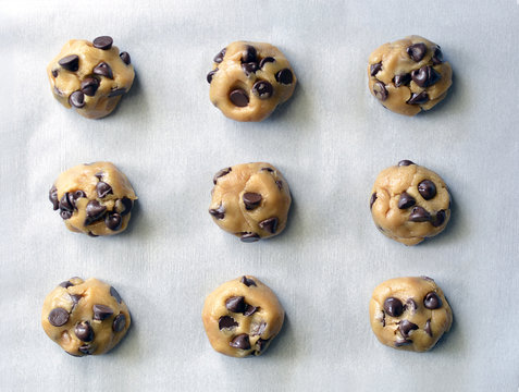 Rolled chocolate chip cookie dough on a baking pan