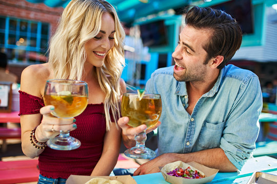 romantic couple with beers at outdoor mexican restaurant