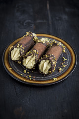 Italian dessert cannoli with pistachios,selective focus