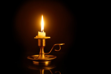 Burning candle on candlesticks