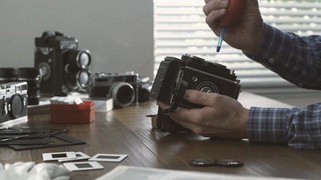Professional photographer cleaning a twin lens camera