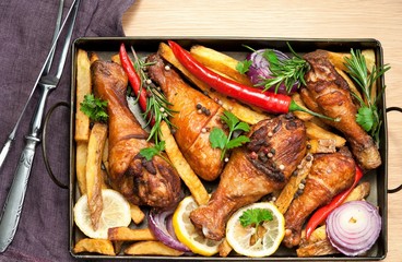 Grilled spicy chicken legs with pepper, lemon and potatoes