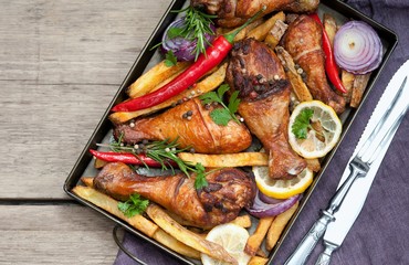 Grilled spicy chicken legs with pepper, lemon and potatoes