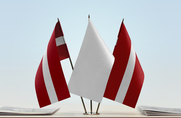 Two flags of Latvia with a white flag in the middle