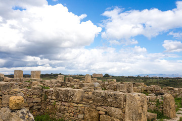 Fototapeta na wymiar SICILY, TRAPANI, SELINUNTE: Ancient greek temple at the archeological site of Selinunte, Trapani, during a sunny day with clouds, green fields and a perfect blue sky of early spring.