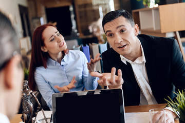 Young divorcing couple emotionally communicate in divorce lawyer office.