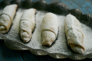 Biscuits with walnuts and sugar powder, oriental sweets mutaki pastry on rustic wooden blue table background, close-up