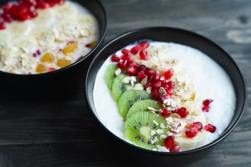 Delicious low calorie yoghurt oatmeal smoothie bowl decorated with fruit slices and pomegranate. Healthy tasty diet food