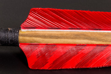 Super macro of the back of red black and brown medieval arrow nock fletching shaft vanes