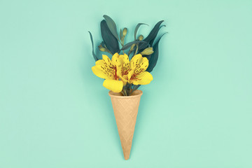 Spring is coming. Bouquet of yellow flowers with green leafs in waffle cones on design blue background