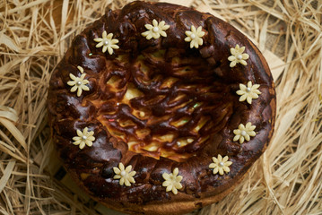 Traditional Ukrainian wedding bread korovai or karavai with decorations on rustic straw background. 