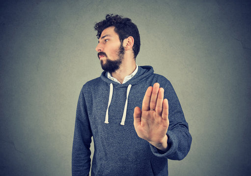 Annoyed angry man with bad attitude giving talk to hand gesture