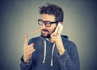 sly liar man with long nose talking on mobile phone