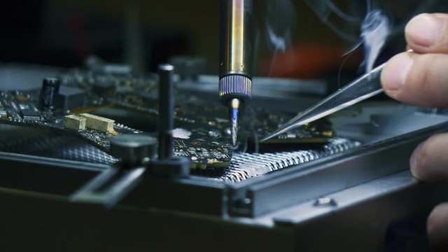 Man fixing a crashed drone with soldering iron. Tracking shot. Close up. 4K