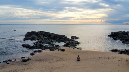 Fototapeta na wymiar lonely girl sitting on the beach - loneliness