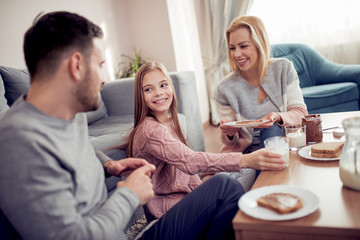 Obraz premium Family of three having breakfast in the morning together