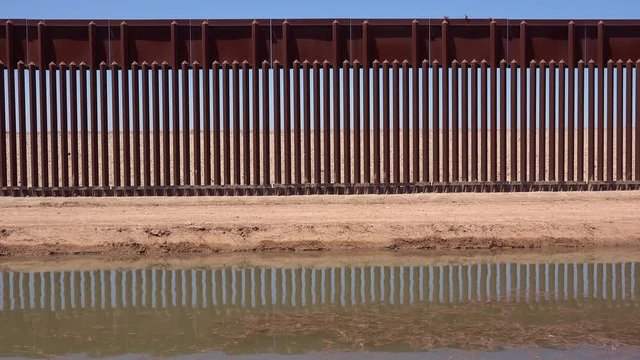 A tributary of the Colorado River flows along the border wall between the US and Mexico.