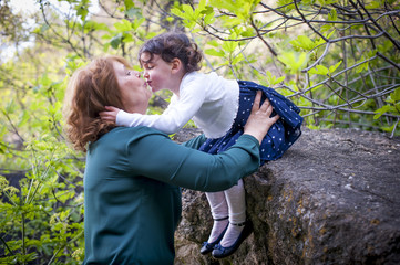 Fototapeta premium Grandmother hugging her granddaughter in the park