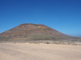 Fototapeta na wymiar Agujas Grandes volcano wit colourful rock strata, La Graciosa, Canary Islands