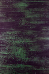 brushstrokes with thick paint in shades of green, blue, purple on old wooden texture