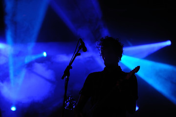 Fototapeta na wymiar Silhouette of an unrecognizable man playing an electric guitar
